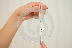 A girl fills a syringe for insulin injections. Diabetes. The short-acting insulin. Insulin injection at home.