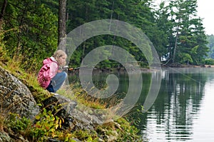 Girl fishing on the bank of a lake