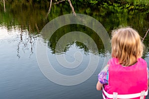 girl fishing with blue water in background