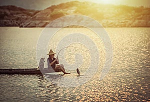 Girl is fishing on boat with her dog