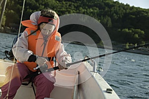 Girl with a fishing rod in a boat