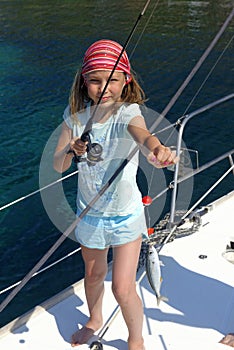 Girl fishing on a sailing yacht