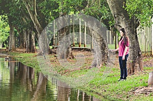 Girl fishing, standing in front of a lake, holding a fishing rod