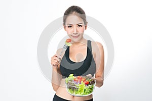 Girl in a fitness suite holds a salad bowl