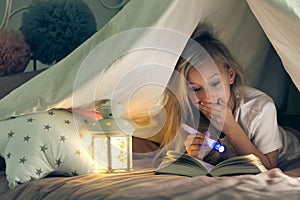 Girl with flashlight reading book