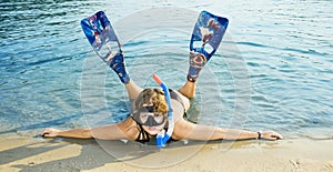 Girl in Flipper lying on the beach