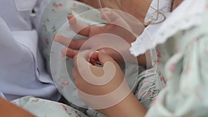 a girl in a floral dress measuring her parents' wedding rings.