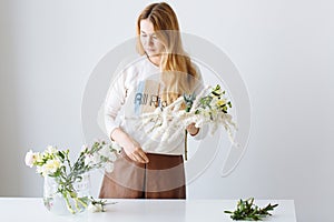 Girl florist assembling a bouquet