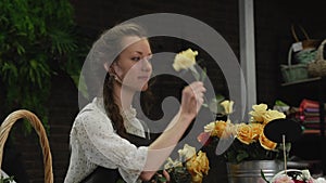 Girl florist collects a bouquet of roses