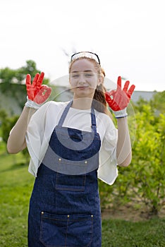 Girl, florist working in garden, showing alright, smiling.