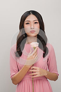 Girl with flower. Beautiful young woman holding red rose and smiling