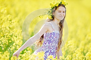 Girl with flower garland at yellow seed meadow