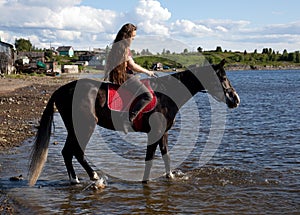 A girl with flowing hair on a black horse