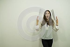 Girl with flowing hair and an open mouth in shock is standing on the right holding white sheets in her hands holding them to her e