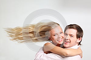 Girl with flying hair embraces young man