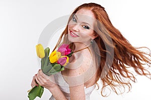 Girl with flying hair is holding colorful tulips