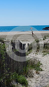 Girl flying a kite. Holidaying at the beach and having fun