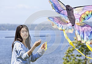 Girl flying kite by the lake