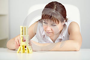 Girl is focused to build a tower with domino