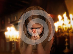 Girl folded her hands in a prayerful gesture. Child praying in the temple