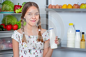 Girl with food near fridge