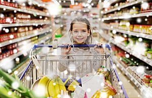 Girl with food in shopping cart at grocery store