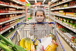 Girl with food in shopping cart at grocery store