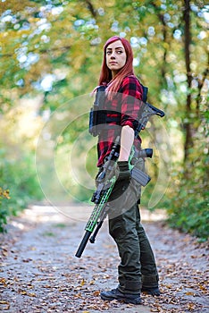 Girl on a forest road with a rifle