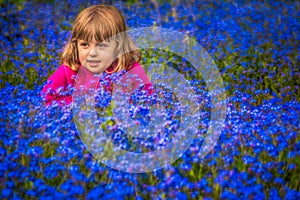 Girl among forget-me-nots flowers