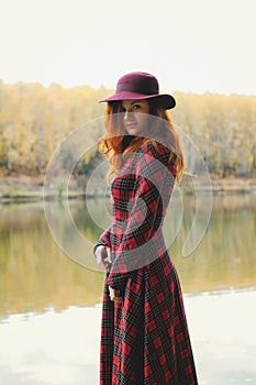 Girl with freckles and blue eyes dreaming in autumn forest