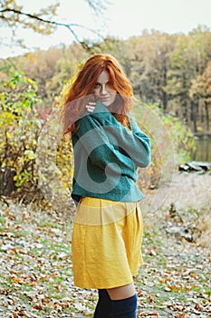 Girl with freckles and blue eyes dreaming in autumn forest