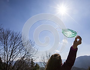 Girl freeing herself from the protective mask after overcoming illness, virus, covid-19. coronavirus