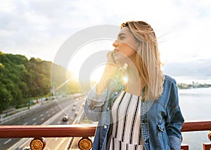 Girl freelancer at sunset speaks on the phone and works