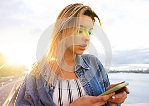 Girl freelancer at sunset speaks on the phone and works