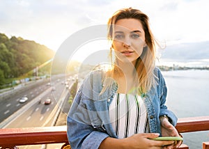 Girl freelancer at sunset speaks on the phone and works