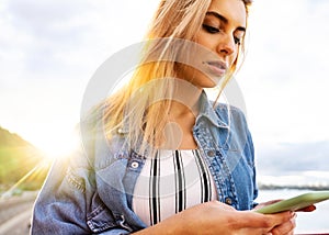 Girl freelancer at sunset speaks on the phone and works