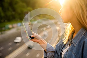 Girl freelancer at sunset speaks on the phone and works