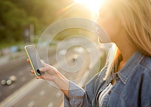 Girl freelancer at sunset speaks on the phone and works