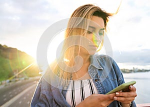 Girl freelancer at sunset speaks on the phone and works