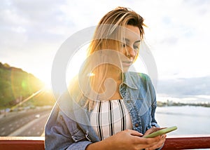 Girl freelancer at sunset speaks on the phone and works