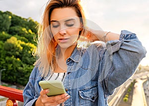 Girl freelancer at sunset speaks on the phone and works