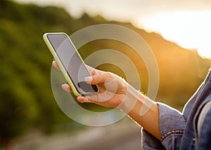 Girl freelancer at sunset speaks on the phone and works