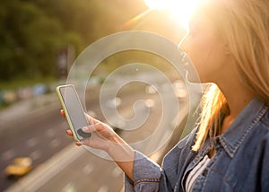 Girl freelancer at sunset speaks on the phone and works