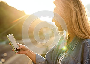 Girl freelancer at sunset speaks on the phone and works