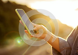 Girl freelancer at sunset speaks on the phone and works, blurred