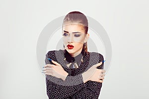 Girl freezing. Business woman hugging herself with hands trying to warm up on a white background. Beauty in formal shirt with full