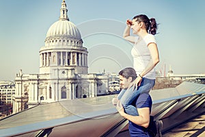 Girl on a friend`s shoulder looks towards the city