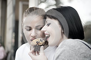 Girl friends eat blueberry muffin in paris, france