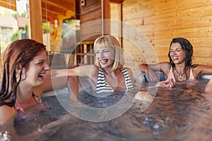 Girl friends relaxing in hot tub while on vacation