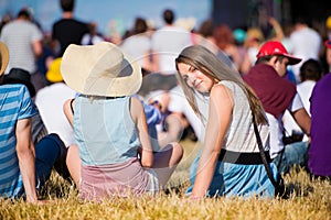 Girl with friends, teenagers, summer festival, sitting on grass